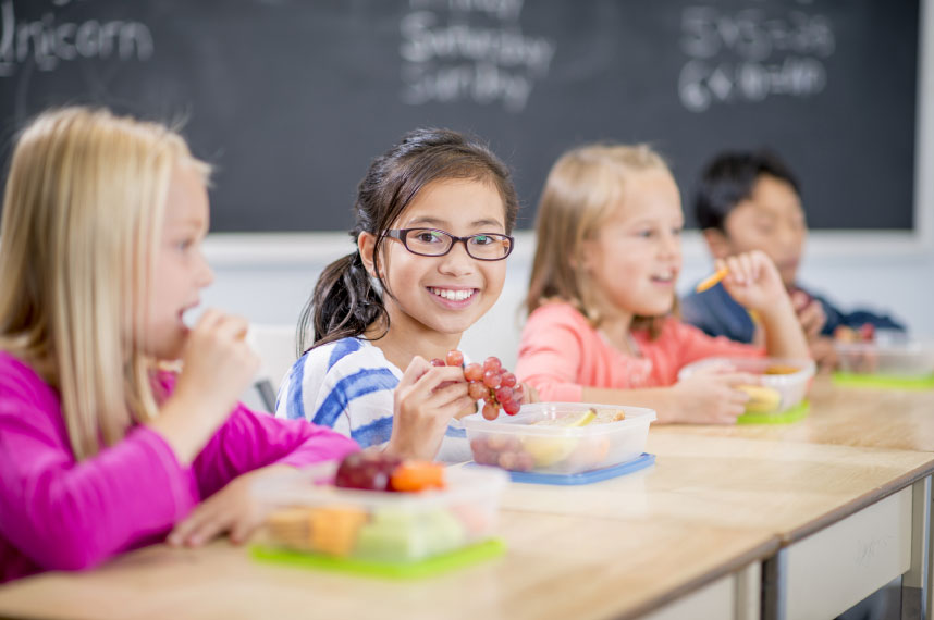 Three children eating a school lunch