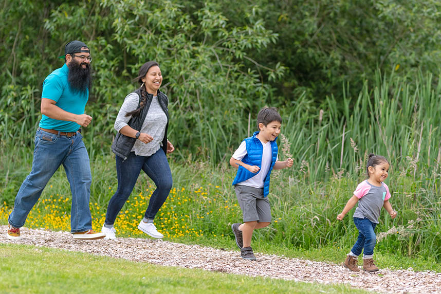 Two young kids and their parents walking out in nature