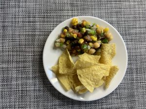 Recipe with corn tortilla chips on a white plate, resting on a checkered tablecloth