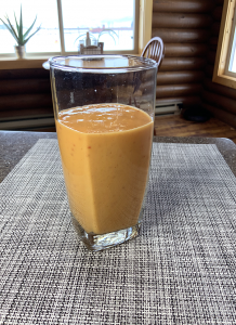 blended drink in clear glass on woven placemat