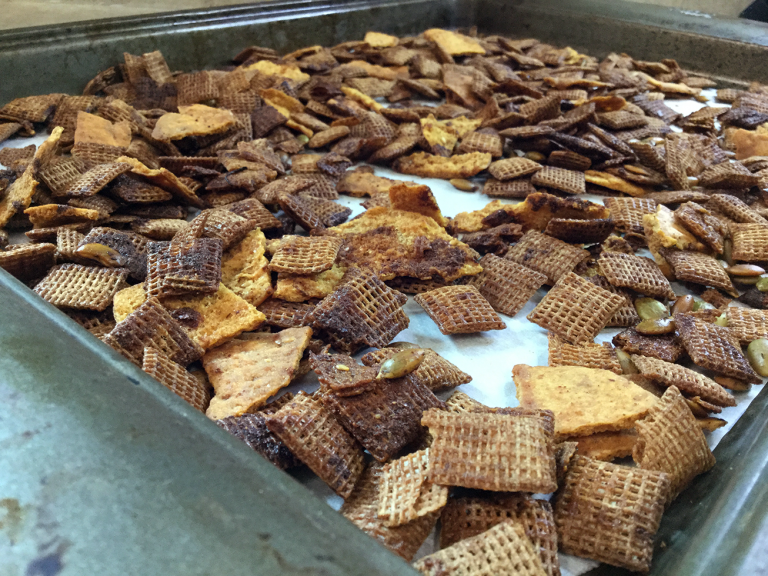 browned cereal and pita chips on a metal baking sheet