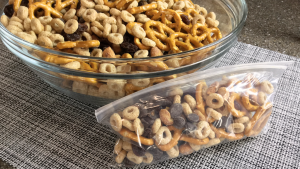 trail mix in clear glass bowl, portion of snack in small resealable plastic bag