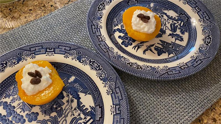 Peaches with cottage cheese and raisins on blue patterned plates