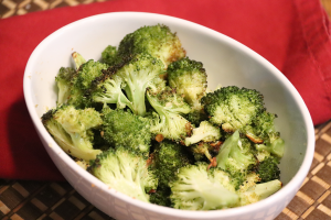 roasted broccoli in white bowl with red napkin