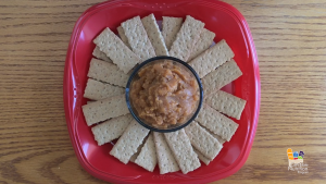 Dip on red plate surrounded by graham crackers