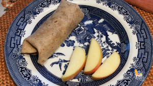 burrito and apple slices on blue plate