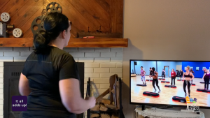 woman moving with aerobic video on TV