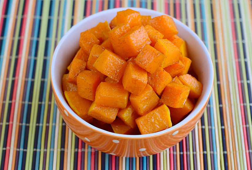 Orange bowl of diced sweet potatoes sprinkled with cinnamon,