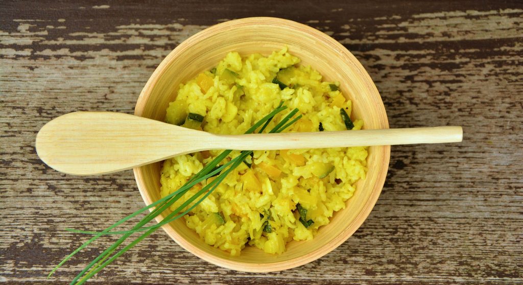 rice in bowl with garnish and wooden spoon on top