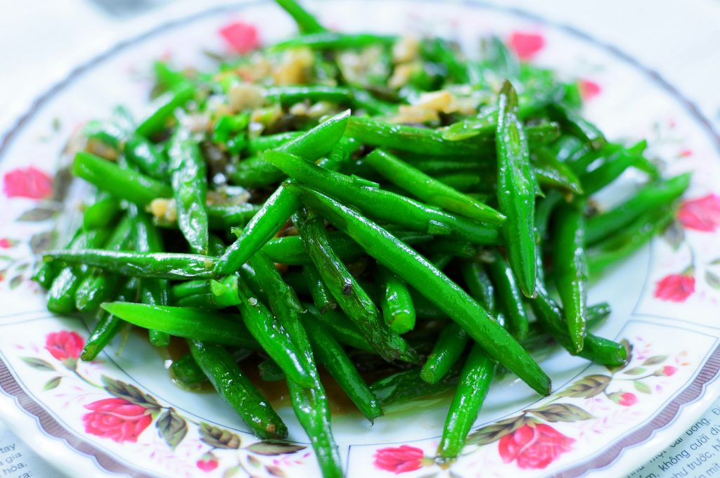 seasoned cooked green beans on flowery plate