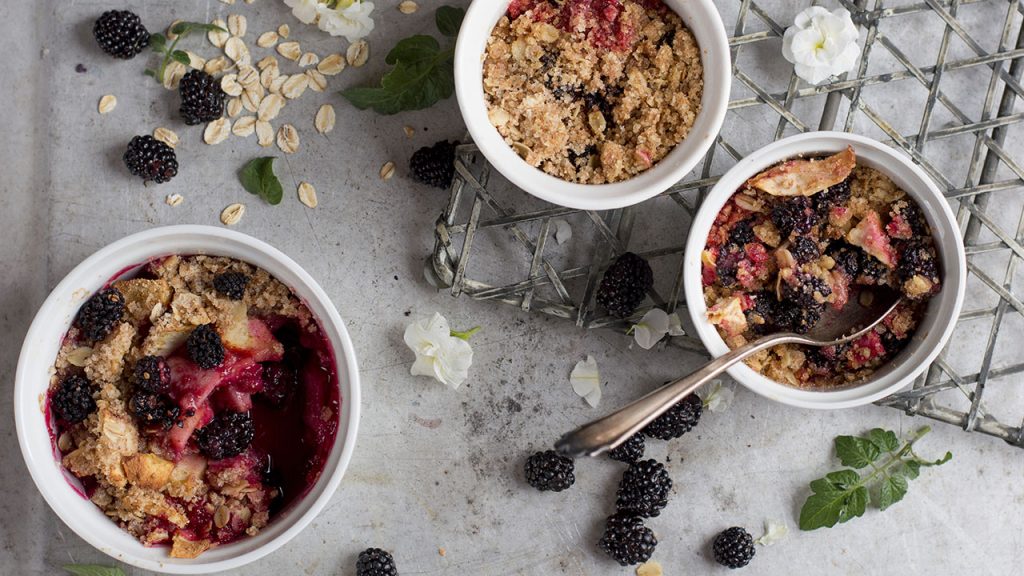 Three white bowls of berry crisp