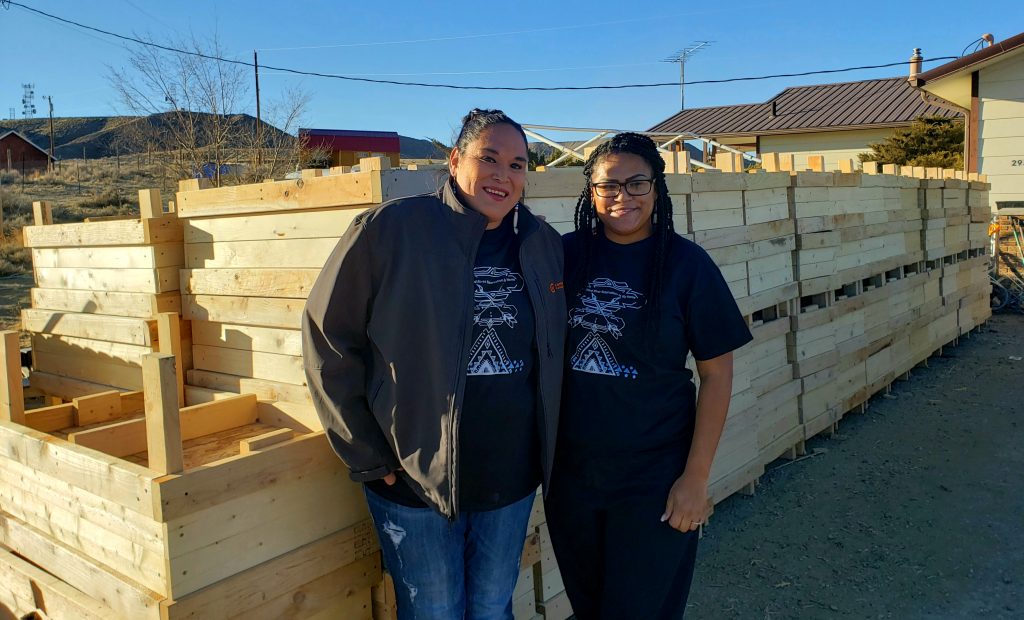 Darrah and Deneica in front of wooden garden boxes