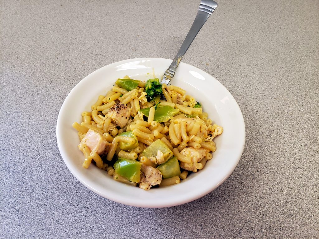 Broccoli and chicken mac and cheese in a white bowl
