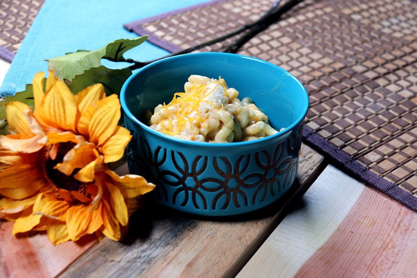 Bowl of butternut mac and cheese topped with cheese