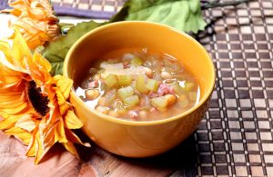 Bowl of bean soup with ham, onions, and celery