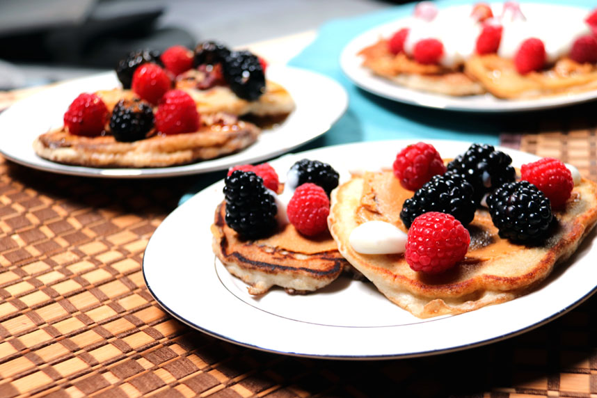 Blueberry pancakes topped with peanut butter, berries, and yogurt