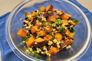 Bowl of roasted sweet potatoes, black beans, corn, and cilantro.