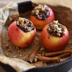 Three apples stuffed with filling in a baking pan