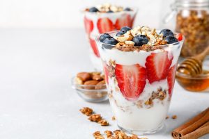Two classes of yogurt, strawberries, blueberries and granola