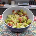 Bowl of diced cucumbers, tomatoes, and green pepper in a light vinaigrette dressing