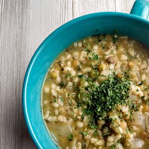 Turquoise bowl of soup made with barley, lentils, and rice