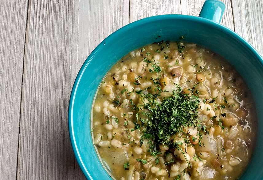 Turquoise bowl of soup made with barley, lentils, and rice