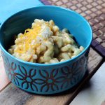 Blue bowl of mac and cheese on a wooden background