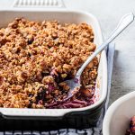 Baking dish of blueberries topped with an oat crumb topping