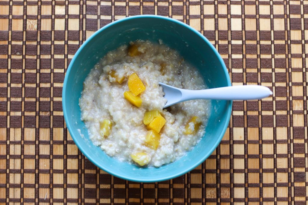 Bowl of microwave oatmeal with canned peaches on top