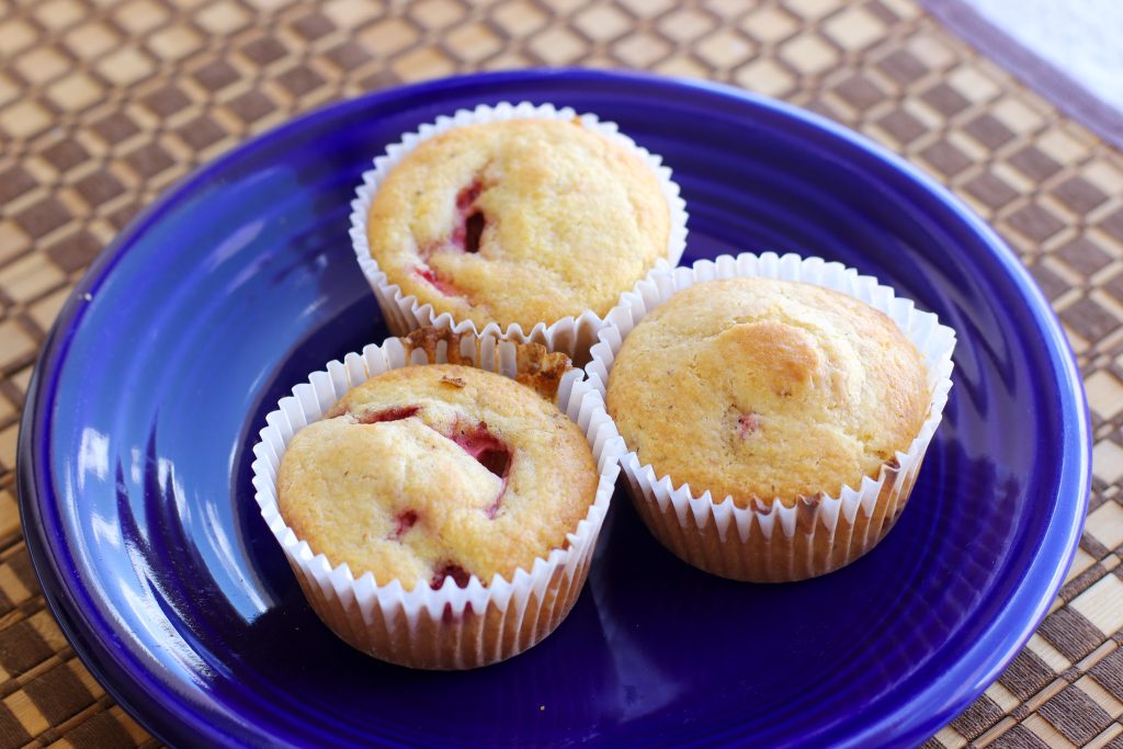 Three fruit muffins on a blue plate