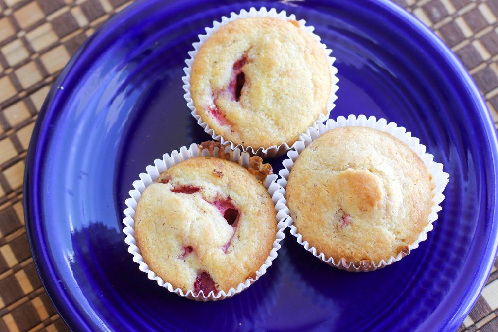 Three fruit muffins on a blue plate