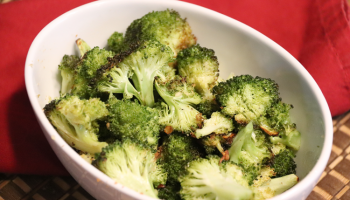 roasted broccoli in white bowl with red napkin