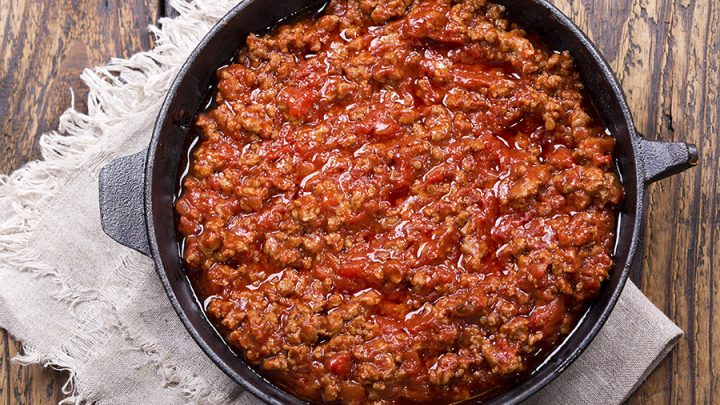 pan of sauce bolognese on wooden table, top view