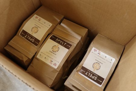 Sealed paper bags filled with Wyoming Heritage Grains stone milled spelt flour in box.