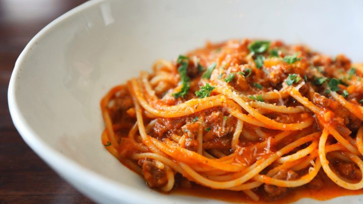 spaghetti with meat sauce in white pasta plate